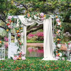 an outdoor wedding ceremony setup with flowers and draping on the arbors, overlooking a pond