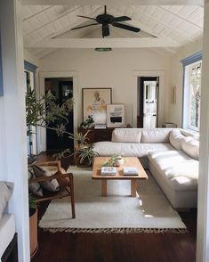 a living room filled with furniture and a ceiling fan