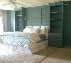 a large bed sitting in the middle of a bedroom next to a bookcase filled with books