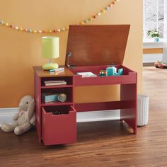 a child's desk with an open drawer on the bottom shelf and a stuffed animal sitting next to it