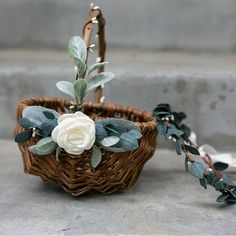 a flower arrangement in a basket on the ground