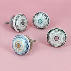 four ceramic knobs on a pink background