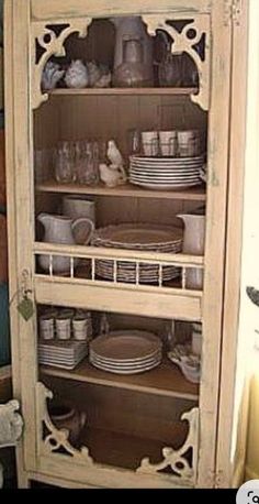 an old china cabinet with dishes and plates