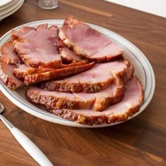 slices of ham on a plate with silverware