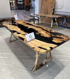 a wooden table sitting on top of a white floor next to tables with chairs in the background