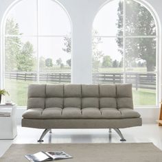 a couch sitting in front of two large windows