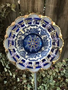 a blue and white plate sitting on top of a metal pole