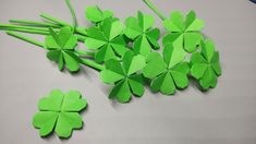 four leaf clovers sitting on top of a white table next to green straws