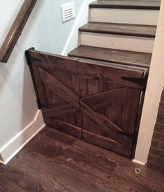 a wooden cabinet sitting on top of a hard wood floor next to a stair case