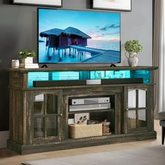 a flat screen tv sitting on top of a wooden entertainment center in a living room