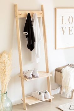 a wooden shelf with shoes on it next to a vase