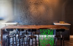 a table with stools in front of it and a drawing on the wall behind it