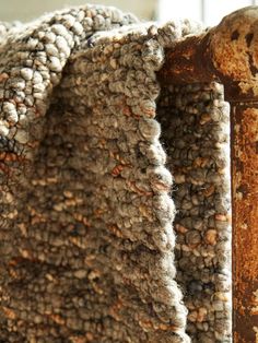 an old rusted iron bed frame with a blanket draped over it