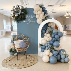 a baby in heaven balloon arch with blue and white balloons