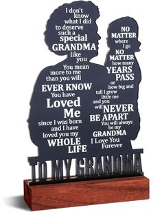 a wooden plaque with two silhouettes and words on it