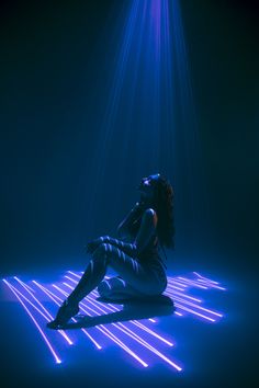 a woman is sitting on the floor with her legs crossed and head turned to the side