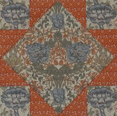 an orange and blue quilt with flowers on the center, surrounded by other fabric material