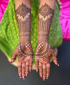 two hands with henna tattoos on them