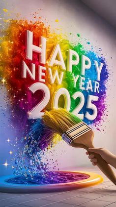 a person holding a paintbrush in front of a happy new year sign with the colors of the rainbow