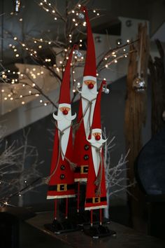 two santa clause figurines sitting on top of a table