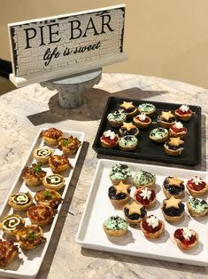 small appetizers are on trays next to a sign