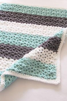 a crocheted blanket laying on top of a bed