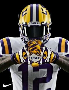 a football player wearing a helmet and holding his hands in front of his face with the words tigers on it