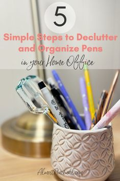 a cup filled with pens and pencils on top of a wooden table