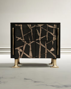 a black and white cabinet with gold legs on marbled flooring in front of a wall