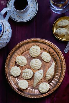 some cookies are on a plate next to a cup and saucer