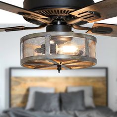 a ceiling fan that is hanging from the ceiling in front of a bed with pillows