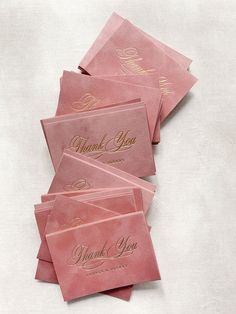 pink thank you cards with gold foil on them are laid out in a row and placed on top of each other