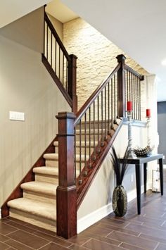 a staircase in a home with white carpet and wood handrails