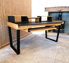 a wooden desk sitting on top of a floor next to a fire place in a room