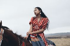 a woman is sitting on top of a horse in an open field with her eyes closed