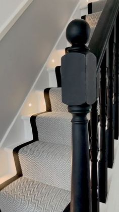 an image of a stair case with carpet on the bottom and handrails down