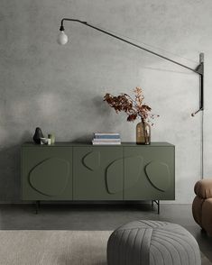 a living room with a couch, chair and sideboard in front of a gray wall