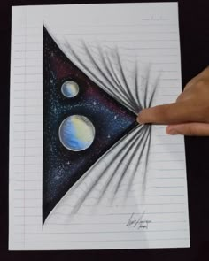 a person holding up a piece of paper with three planets on it