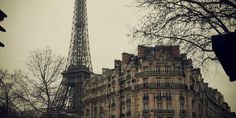 the eiffel tower is seen from across the street in front of an old building