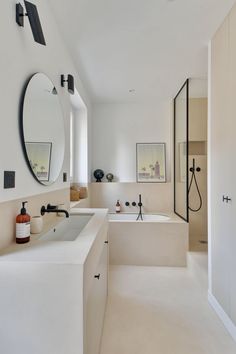 a bathroom with two sinks, mirrors and a bathtub in it's center