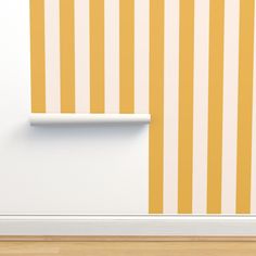 an empty room with yellow and white stripes on the wall, next to a shelf