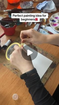 a person is painting on a wooden table