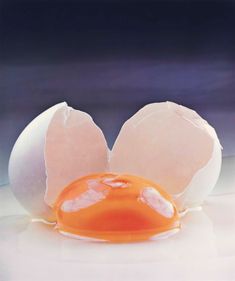 an egg is broken in half on a white surface