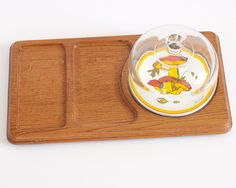 a wooden tray with a glass bowl on it