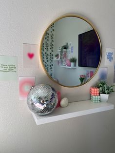 a mirror and disco ball on a shelf