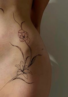 a woman's stomach with a flower tattoo on it