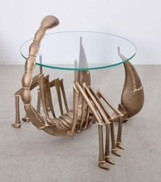 a glass table topped with metal chairs and a circular glass top sitting on concrete flooring