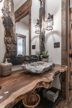 a bathroom with a wooden counter top and large mirror above it, along with two lights on the wall