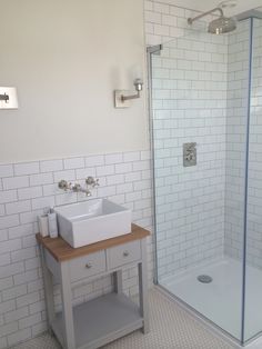 a bathroom with a sink, shower and stand up shower stall in the middle of it