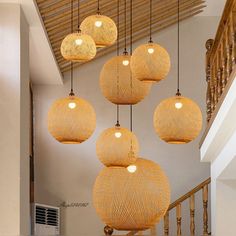 a bunch of lights hanging from the ceiling in a room with stairs and banisters